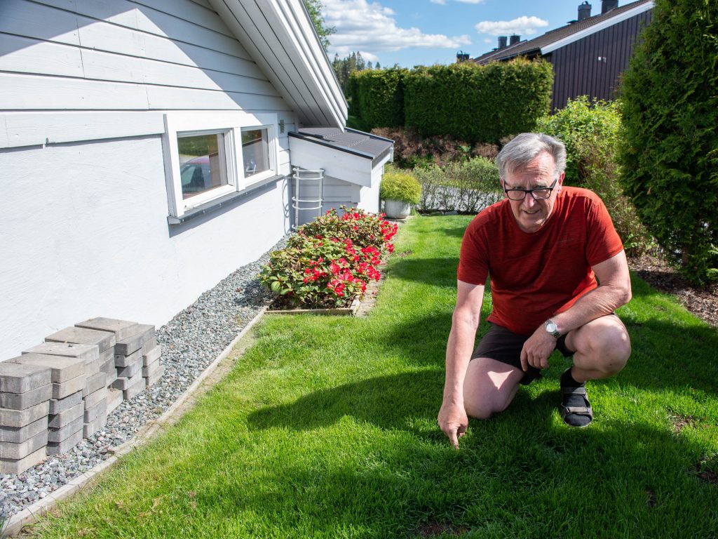 Stein Bakken over energibrønn i bergvarmeanlegget, nå  dekket med grønt gress 